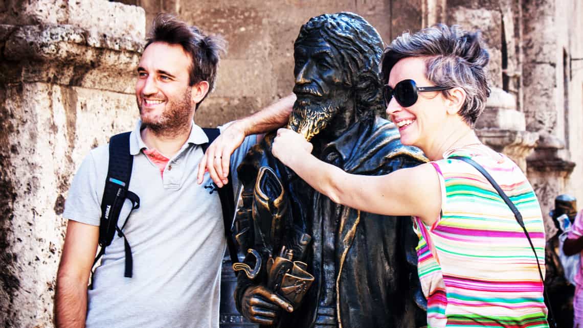 Viajeros posando para una foto junto a la estatua de el Caballero de París