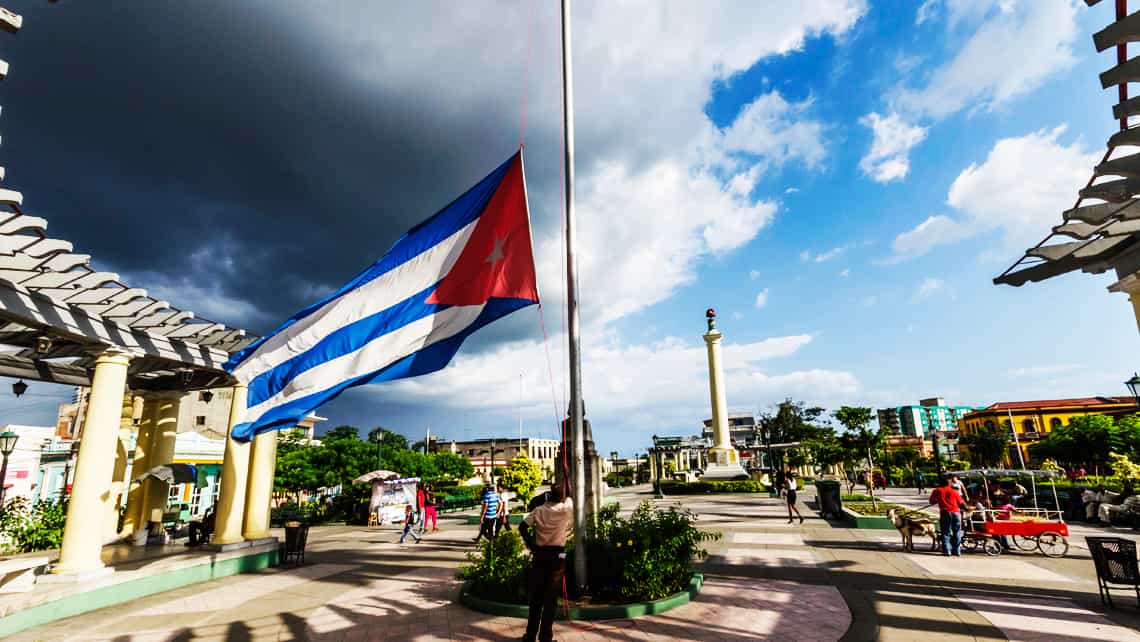 Funcionarios izando la bandera Cubana en la Plaza de Marte en Santiago de Cuba