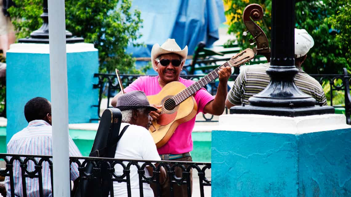 Musico callejero cantandole a turistas en Santiago de Cuba