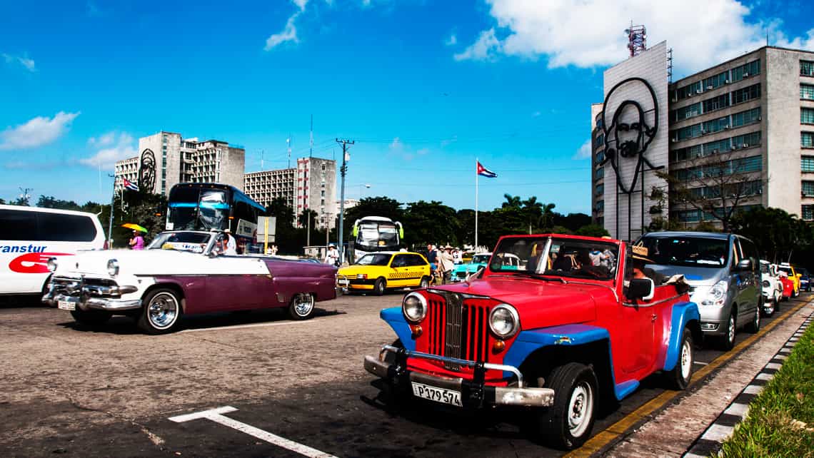 Turistas en coches antiguos en la Plaza de la Revolucion