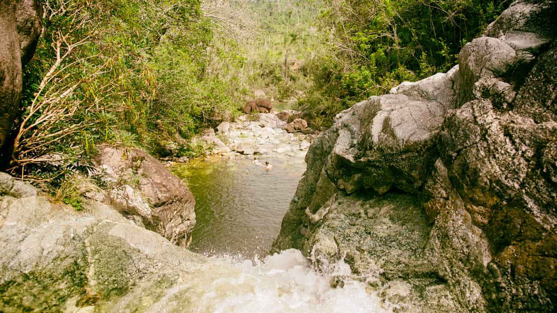 Vista del Rio Duaba desde una de las cascadas, debajo muchachos nadando en el agua