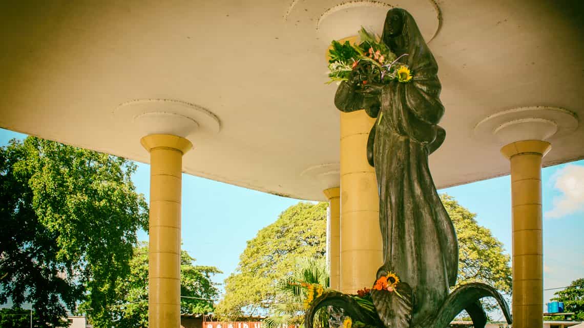 Vista de la Virgen del Camino con flores que han dejado los transeuntes