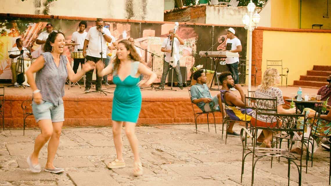 Dos turistas bailan al ritmo de la musica en vivo en la Casa de la Musica de Trinidad
