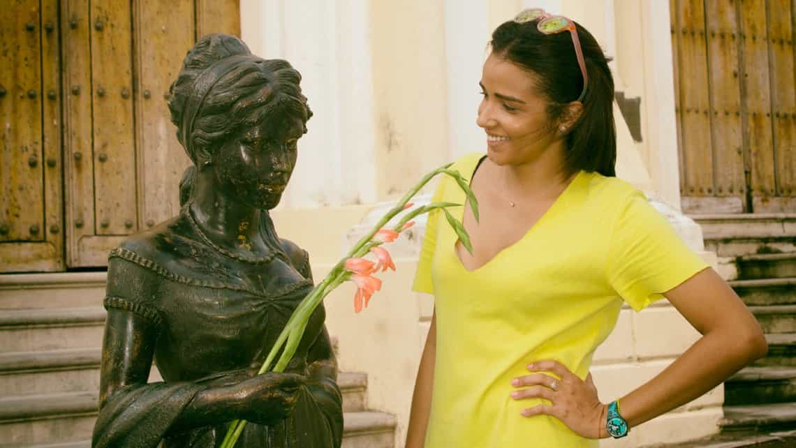 Turista comparte flor con estatua viviente de Cecilia Valdes