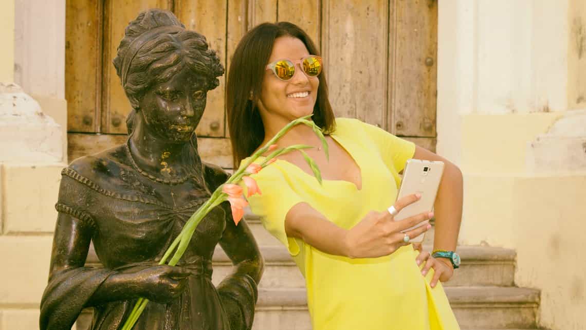 Turista se toma selfie con la estatua viviente de Cecilia Veldes en la Plazuela del Angel