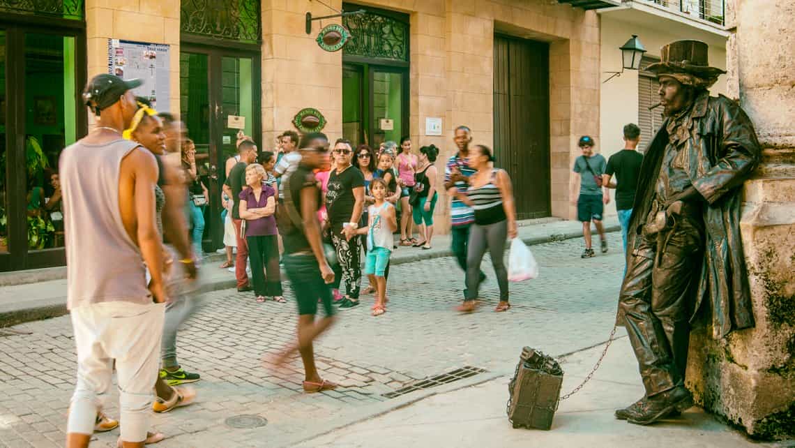 Personas observan a estatua viviente frente al Museo del Chocolate en la Habana Vieja