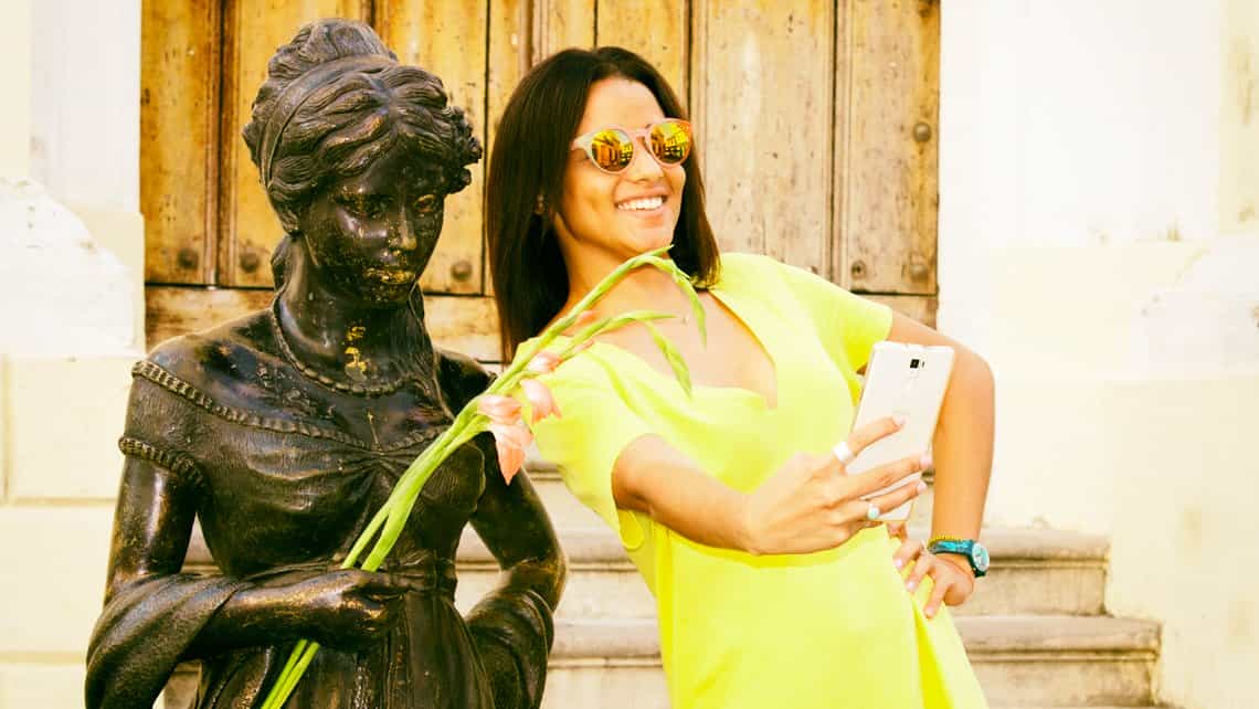 Viajera se toma un selfie con una estatua viviente de Cecilia Valdes en la Plazuela del Angel